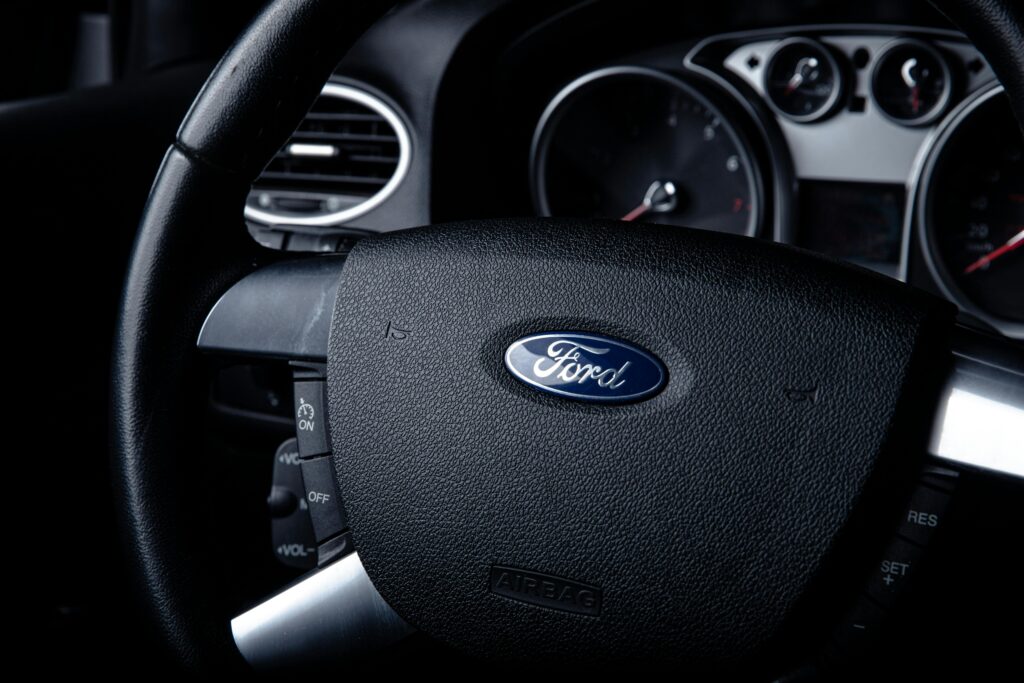 Detailed close-up of a Ford car steering wheel with instrument panel visible in the background.